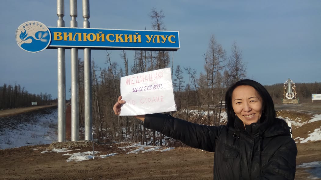 Исполнительный директор на фоне столбца Вилюйский улус с бумажкой медиация шагает по стране